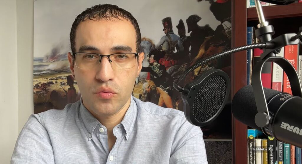 Alexander Velásquez habla delante de un micrófono.