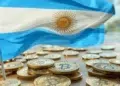 Bandera Argentina sobre varias monedas con el logo de BTC.