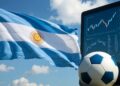 Bandera de Argentina junto a un balón de fútbol y un monitor con distintos tipos de indicadores.