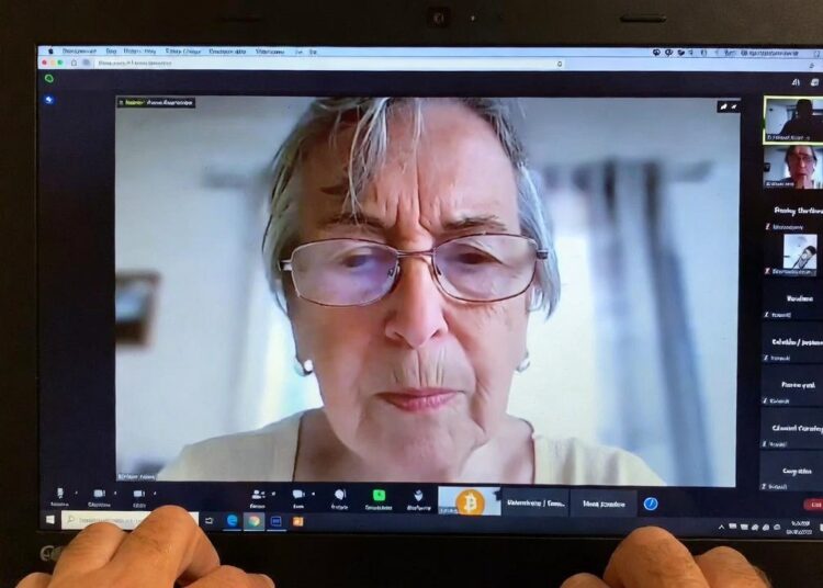 Una señora aparece en una llamada de Zoom recibiendo indicaciones para recuperar sus bitcoin.