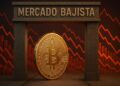 Moneda física de bitcoin con un letrero que dice "mercado bajista" y gráficas rojas en el fondo.