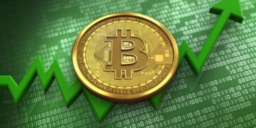 Moneda física de bitcoin dorada con una flecha verde debajo y un escritorio en verde.