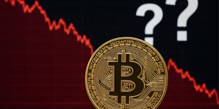 Moneda física de bitcoin dorada con gráficas rojas y signos de interrogación.