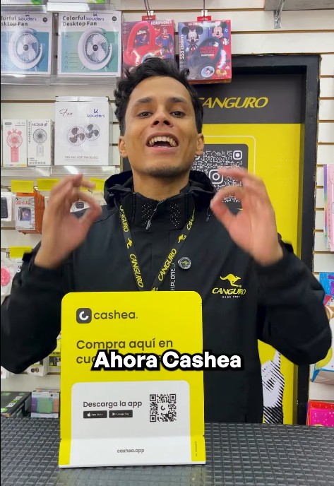 Un hombre en una tienda Canguro el con logo en su chaqueta, promociona el servicio de Cashea.