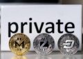 Monedas físicas de monero, zcash y dash delante de cartel que dice private.