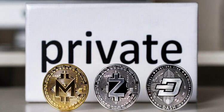 Monedas físicas de monero, zcash y dash delante de cartel que dice private.