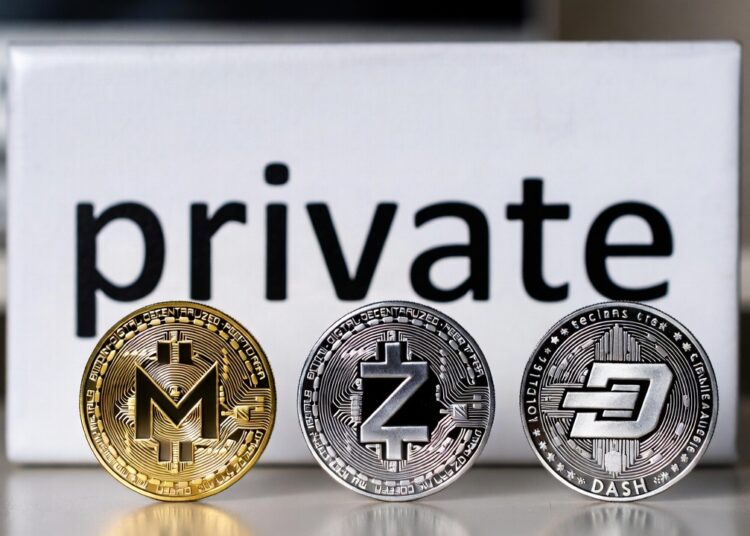 Monedas físicas de monero, zcash y dash delante de cartel que dice private.