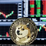 Moneda fรญsica de dogecoin en primer plano, al fondo un panel electrรณnico tรญpico de Wall Street lleno de grรกficos de velas rojas y verdes.
