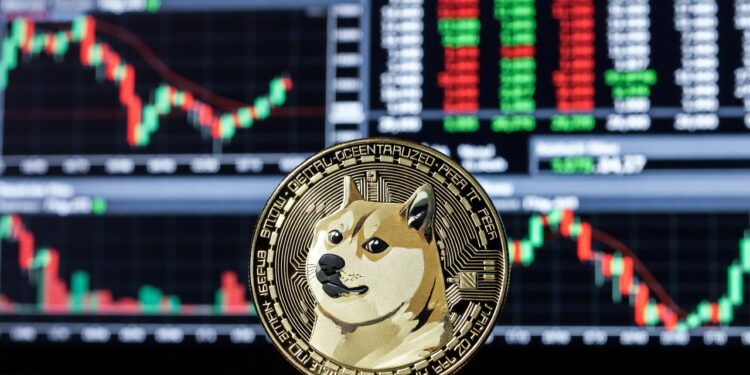 Moneda física de dogecoin en primer plano, al fondo un panel electrónico típico de Wall Street lleno de gráficos de velas rojas y verdes.