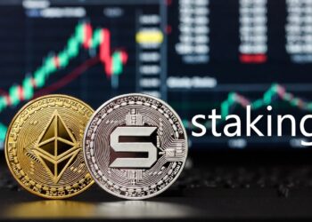Dos monedas físicas de Ethereum y Solana, colocadas lado a lado, a la derecha la palabra staking, con un gráfico bursátil desenfocado.