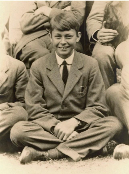 fotografía en colores sepia del joven Morcom, vestido con traje y corbata, probablemente la ropa del internado.