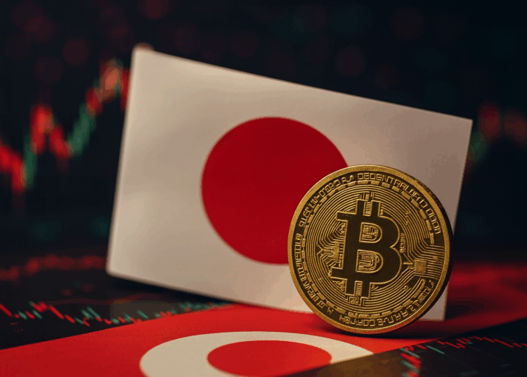 Moneda de Bitcoin en primer plano junto a la bandera de Japón, con gráficos financieros difuminados al fondo