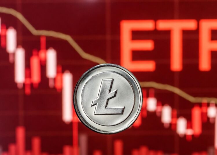 Moneda física de litecoin en primer plano sobre un fondo desenfocado de gráfico bursátil en tonos rojos.