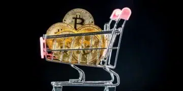 Carrito de supermercado cargado con varias monedas que tienen el logo de Bitcoin.
