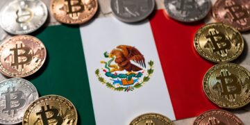 Bandera de México rodeada de monedas físicas con el logo de bitcoin.