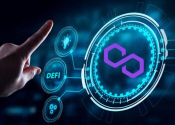 Mano de una persona en traje a punto de tocar el logo de Polygon reflejado en una pantalla digital.