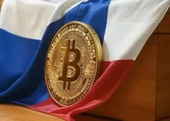 Bandera de República Checa junto a una moneda física de Bitcoin.