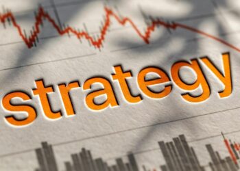 La palabra “strategy” en letras naranja intenso con efecto relieve con un fondo de gráfico bursátil.