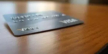 Tarjeta física VISA de color gris sobre una mesa.