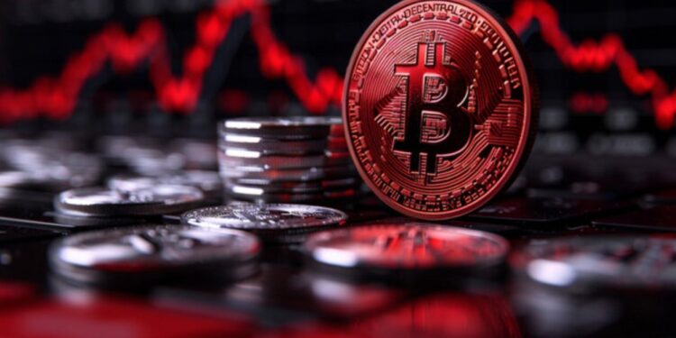 Moneda física de bitcoin con otras monedas alrededor y gráficas rojas.