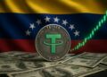 Moneda física de USDT sobre billetes de dólar, con la bandera de Venezuela en el fondo y una gráfica en verde.