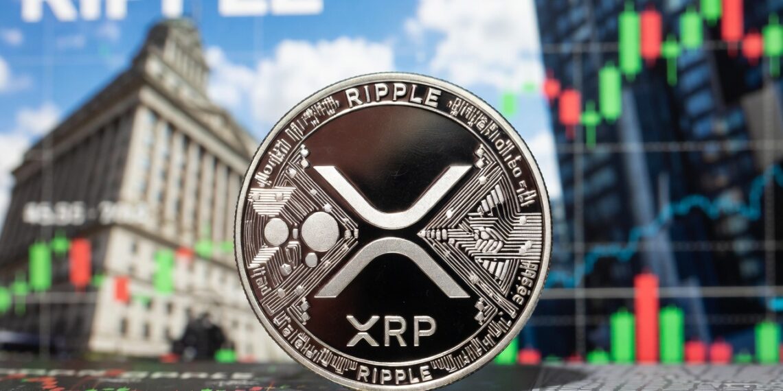 Moneda física de XRP en primer plano e imágenes típicas de Wall Street en el fondo.