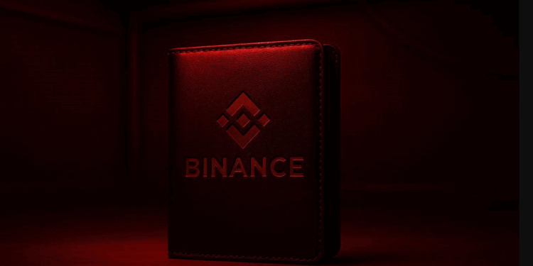 Una wallet de Binance iluminada por una luz roja, como de habitacion de revelacion de fotos .