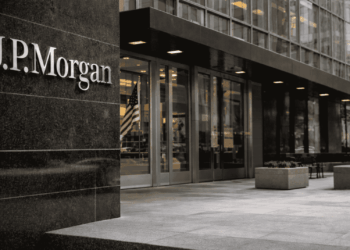 Fachada del edificio de JP Morgan, con su logotipo visible, entrada acristalada y plaza exterior vacía.