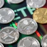 Varias monedas fรญsicas de XRP dispersas y un grรกfico bursรกtil en tonos verdes y rojos.
