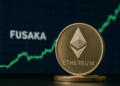 Moneda dorada de Ethereum en primer plano; detrás, pantalla oscura con gráfico verde ascendente y la palabra FUSAKA brillante, ligeramente desenfocada.