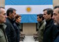 Un grupo de personas de un lado y otro grupo del otro lado mirandose entre sí como peleadas y en el medio la bandera de argentina y bancos.