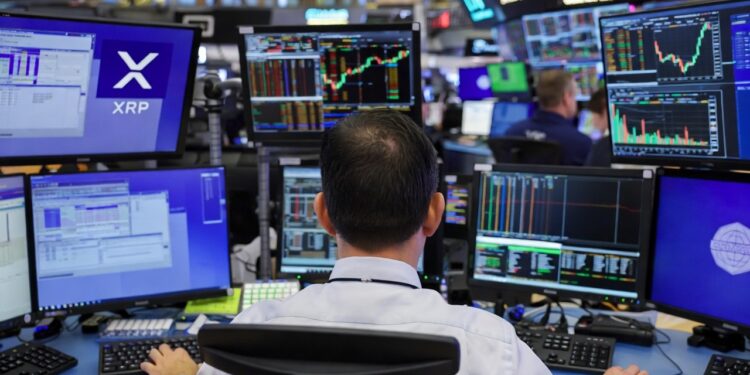 Un trader visto desde atrรกs, sentado frente a una estaciรณn de trabajo con mรบltiples monitores en el piso de operaciones de la Chicago Mercantile Exchange.