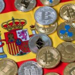 Muchas criptomonedas y detrás la bandera de España