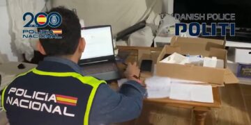 Agente de la policia nacional de españa frentre a una laptop.