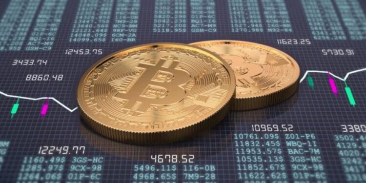 Monedas físicas de bitcoin doradas sobre una mesa con gráficos de trading.