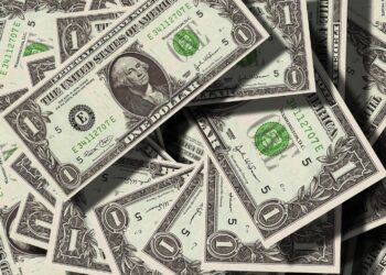 Fotografía de billetes de 1 dólar apilados unos sobre otros.