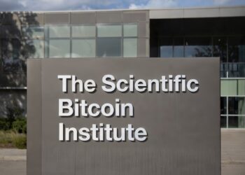 Imagen de un cartel que dice The Scientific Bitcoin Institute, y detrás se ve borroso un instituto.