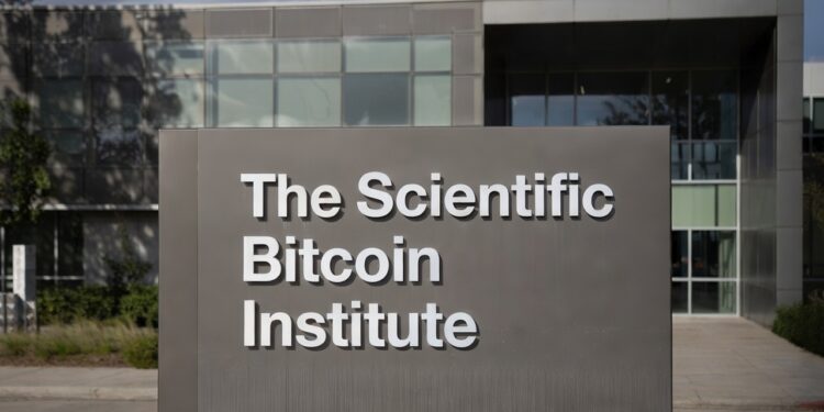 Imagen de un cartel que dice The Scientific Bitcoin Institute, y detrás se ve borroso un instituto.