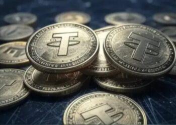 Monedas físicas de USDT sobre un escritorio.