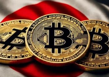 Tres monedas físicas de bitcoin doradas sobre una bandera de Japón.