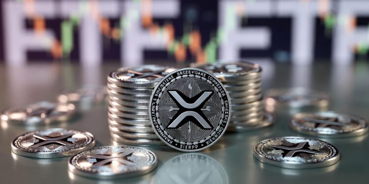Monedas físicas de XRP y al fondo, desenfocado, aparece un gráfico de precios.