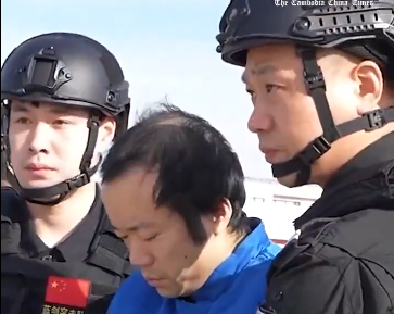 Chen Zhi, acusado de megaestafas con criptomonedas, camina entre dos policías de China.