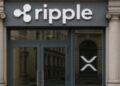 Fachada de una oficina de banco con los logos de Ripple y de XRP.