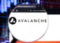 Logo de Avalanche (AVAX) con lupa sobre página web avax.net y gráficos de criptomonedas de fondo.