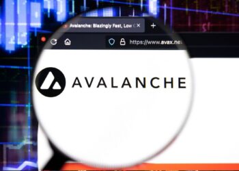 Logo de Avalanche (AVAX) con lupa sobre página web avax.net y gráficos de criptomonedas de fondo.