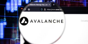 Logo de Avalanche (AVAX) con lupa sobre página web avax.net y gráficos de criptomonedas de fondo.