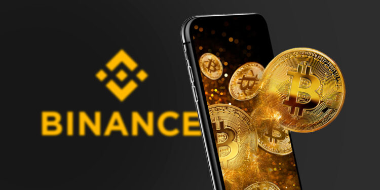 Binance con logo amarillo y un smartphone del que emergen monedas físicas de bitcoin doradas.