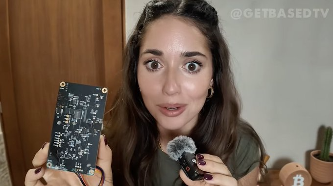 Isabella Santos sosteniendo una pieza de un minero de Bitcoin.