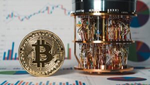 Moneda física de bitcoin dorada al lado de una computadora cuántica y gráficas de mercado en el fondo.