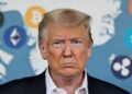 Donald Trump con cara seria y atrás criptomonedas y el mapa de Groenlandia.